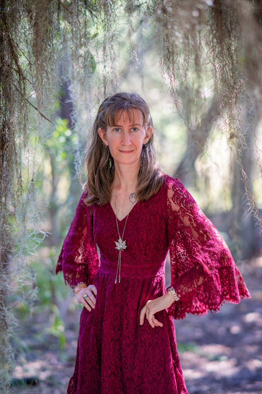 Elizabeth Raley, owner and primary photographer of Elope to Savannah photographed under a live oak tree with Spanish Moss in Savannah